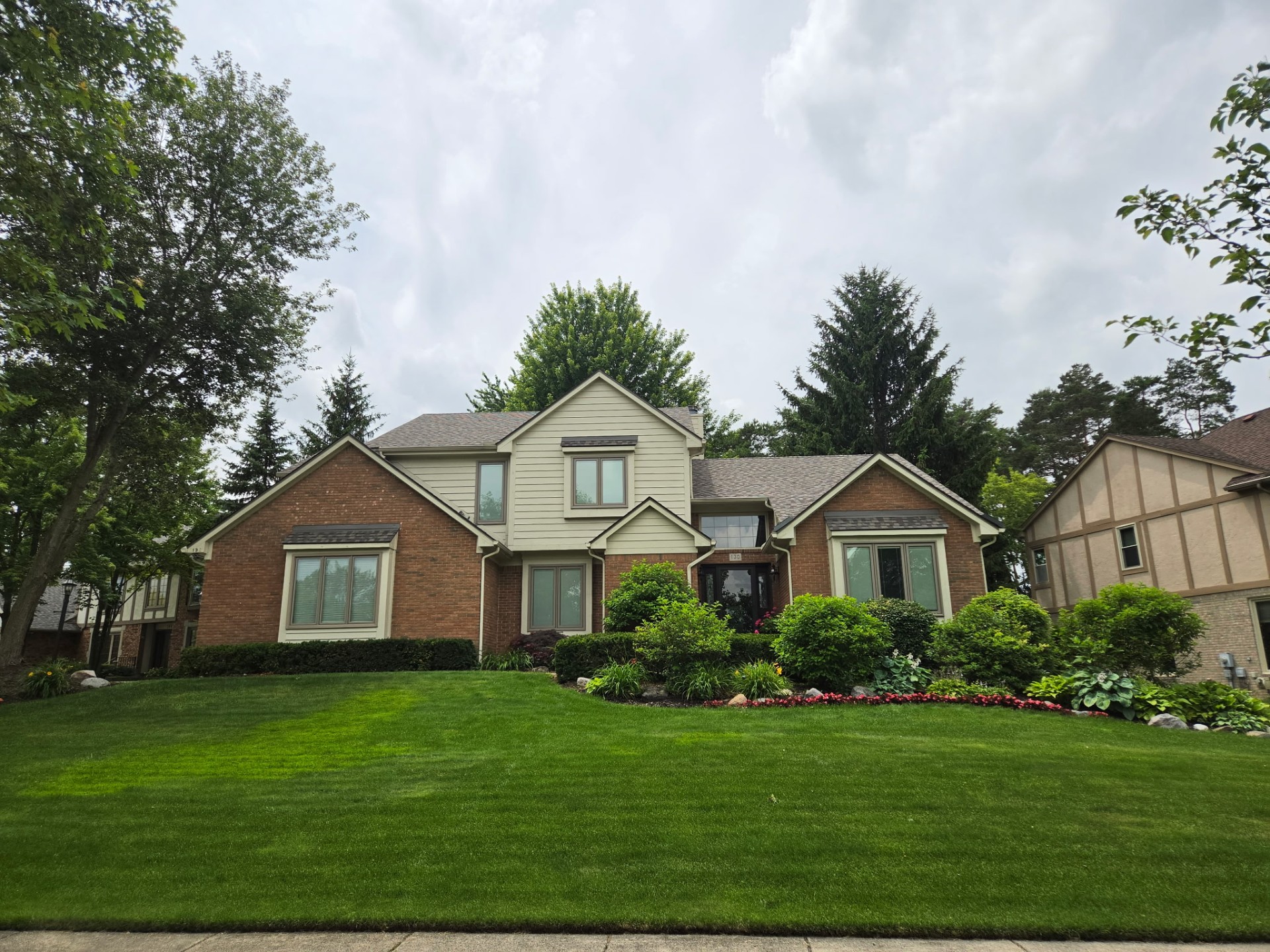 Two-story brick and cedar-sided home in Troy MI with freshly cleaned windows by Apex Exteriors